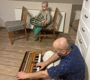 Ishvara plays the harmonium while Prahlad gets acquainted with the mridanga.